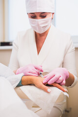 Hypodermic injections with a filler needle - renewal of the condition of the skin of the hands in an older woman