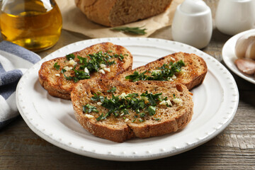 Tasty bruschettas with oil and garlic on wooden table, closeup