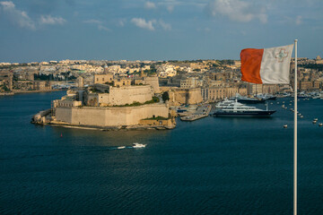 Malta - Valetta - Birgu city on Grand Harbor with fort St Angelo and waving Malta white-red national flag