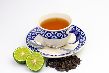 Bergamot tea or Earl Grey tea in white cup and fresh bergamot fruit cut in half isolated on white background.