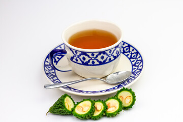 Bitter gourd or bitter melon tea in white cup isolated on white background. Scientific name is Momordica charantia. As a whole food and herbs for treating diseases.