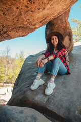 happy woman hiker sitting at the rock