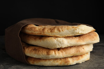 Delicious fresh pita bread and napkin on grey table, closeup