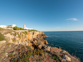 Fototapeta na wymiar Cliffs with fallen rock cliff and formations of Cabo da Guia, next to Cascais and Lighthouse Farol da Guia, Lisbon, Portugal