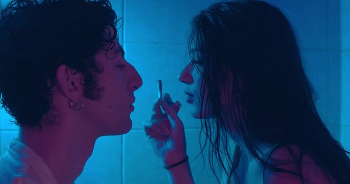 stoned couple - young addicted woman passes a joint of wedd to her boyfriend