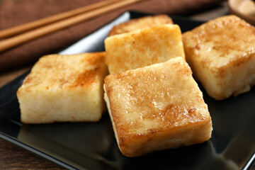 Delicious turnip cake on ceramic black plate, closeup