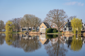 Fototapeta na wymiar Scenic view of a Dutch village reflected in the water on a sunny spring day