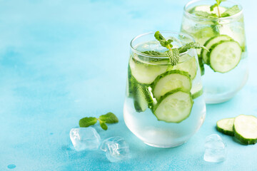 Fresh infused cucumber water on a light blue background