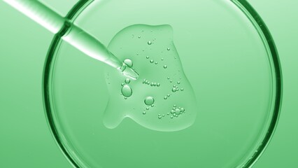 Macro shot of gel with different sized tiny bubbles comes out from chemical dropper into petri dish on green background | Abstract skincare gel with hyaluronic acid formulation concept
