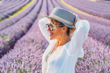 Side portrait of young woman smiling and enjoying outdoor leisure activity with beautiful lavender...