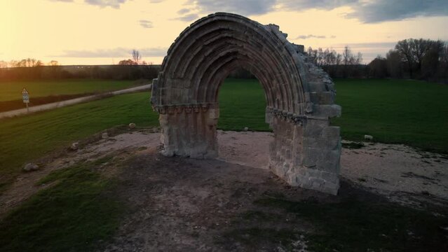 Aerial view of the ruined medieval arch of San Miguel de Mazarreros at dusk, in Olmillos de Sasamon. Burgos, Spain. High quality 4k footage