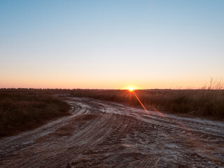 Sunrise in field with path on early autumn morning.