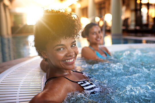 Besties have the best of fun. Portrait of a woman relaxing in a jacuzzi with her friend blurred in the background. - Powered by Adobe