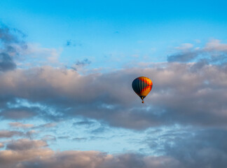 Hot air balloon flying through the cloudy sky