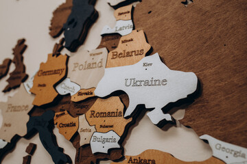 Ukraine on wooden world map with capital of the country Kyiv