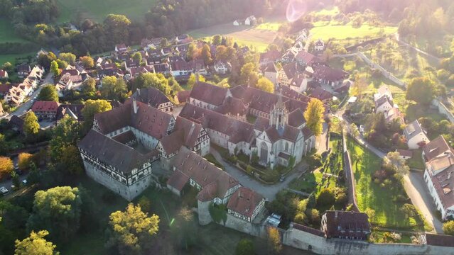 Aerial drone footage of sideways flight over medieval village and monastery of Bebenhausen in Southern Germany at sunset