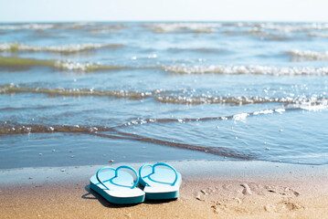 blue beach slippers stand on the seashore