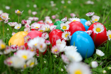 Close up of colored easter egg placed on green grass and colorful spring flowers. Colored eggs is an old Easter tradition that was developed on Romanian soil with great craftsmanship.