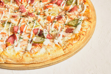 sliced fresh pizza with ham, sausage and pickles on a light background mock-up