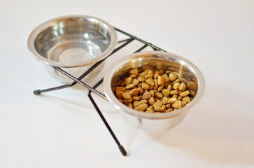 Iron bowls with water and cat food for cat
