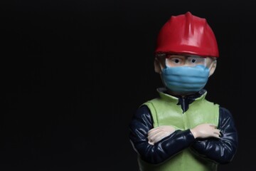 miniature figurine close up portrait of a man wearing protective mask and a worker helmet