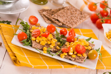 Crispy rye bread with sesame seeds, arugula and sweet corn.
