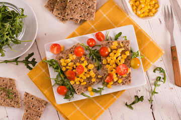 Crispy rye bread with sesame seeds, arugula and sweet corn.
