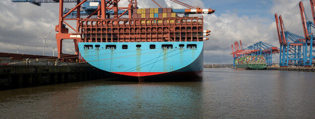 A large container ship is loaded at a terminal in the port of Hamburg