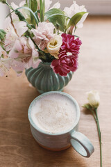 Fototapeta na wymiar Spring morning aesthetics. Stylish ceramic cup of coffee and flowers on rustic wooden background
