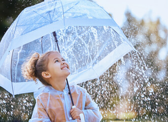 This umbrella will protect me. Shot of a little girl playfully standing in the rain holding her umbrella. - obrazy, fototapety, plakaty