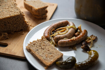 tasty white sausage with onion and gherkins. Homemade bread
