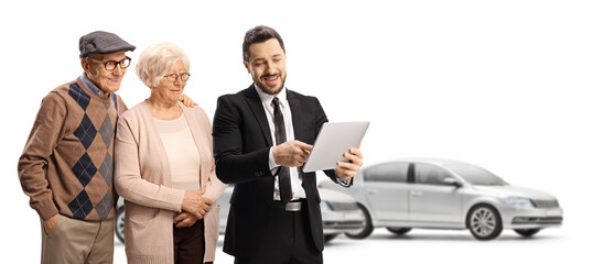 Obraz premium Businessman with a tablet showing to an elderly man and woman in a car showroom