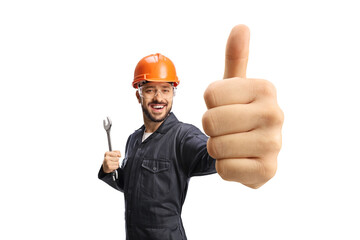 Worker in a uniform with helmet holding showing a thumb up gesture