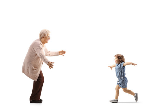 Full Length Profile Shot Of A Child Running Towards Grandmother With Arms Wide Open