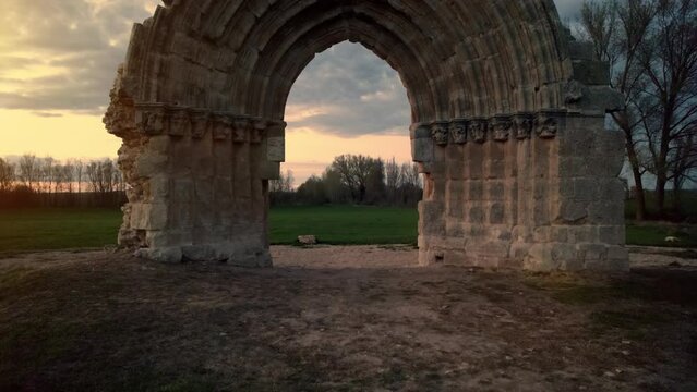 Aerial view of the ruined medieval arch of San Miguel de Mazarreros at dusk, in Olmillos de Sasamon. Burgos, Spain. High quality 4k footage