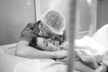 Husband anxiously supports his wife during childbirth