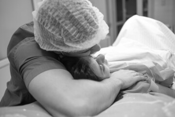 husband tenderly hugs supports his wife during childbirth