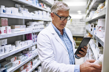 I might actually take some of this later. Shot of a focused mature male pharmacist making notes of the medication stock on the shelves in a pharmacy. - Powered by Adobe