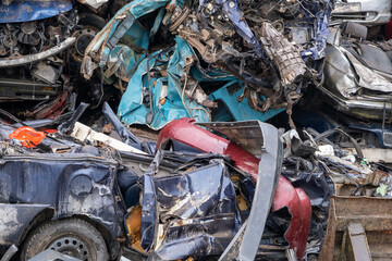 Stacked crushed cars going to be shredded in a recycling facility