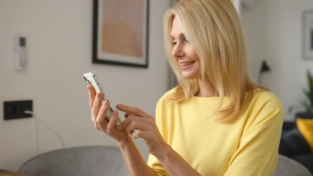 Happy Senior 50s Woman Spends Leisure Time Online, Holding Smartphone, Mid Age Lady Enjoying Chatting Online, Web Surfing, Shopping