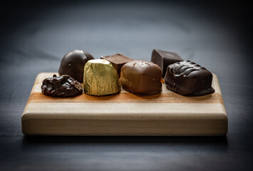 Variety of chocolate candies placed on wooden plank
