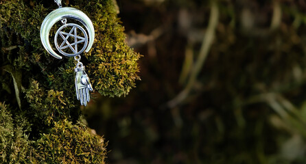 witch amulet with pentagram on moss tree, natural forest background. spiritual ritual. pagan witch...