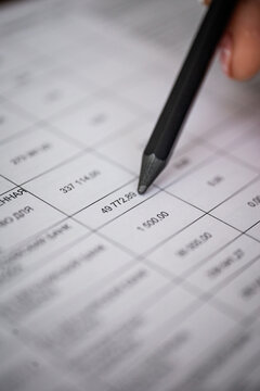 A hand checks part of a financial document