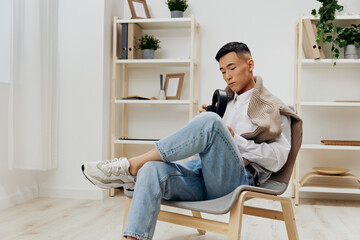 Fototapeta premium man wearing headphones sits in a chair rest technologies