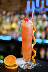 Cocktail garnished with dried orange and cherry on the bar counter. The concept of the correct...