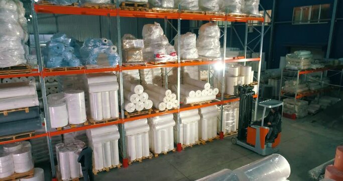Warehouse at the nonwovens factory. Flight to the warehouse of non-woven fabrics. Large modern warehouse with synthetic winterizer rolls