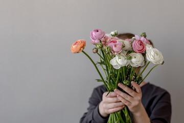 The girl is holding a bouquet of flowers. Ranunculus spring flower. Place for text