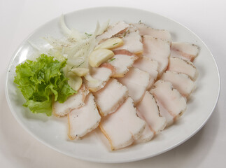 Fresh lard, sliced with greens on a white plate