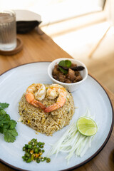 A view of a plate of shrimp fried rice in wood table on a restaurant . Top view. Delicious and easy menu.