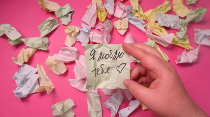 Handwritten text on sticker. The inscription with a marker on paper on a pink background.